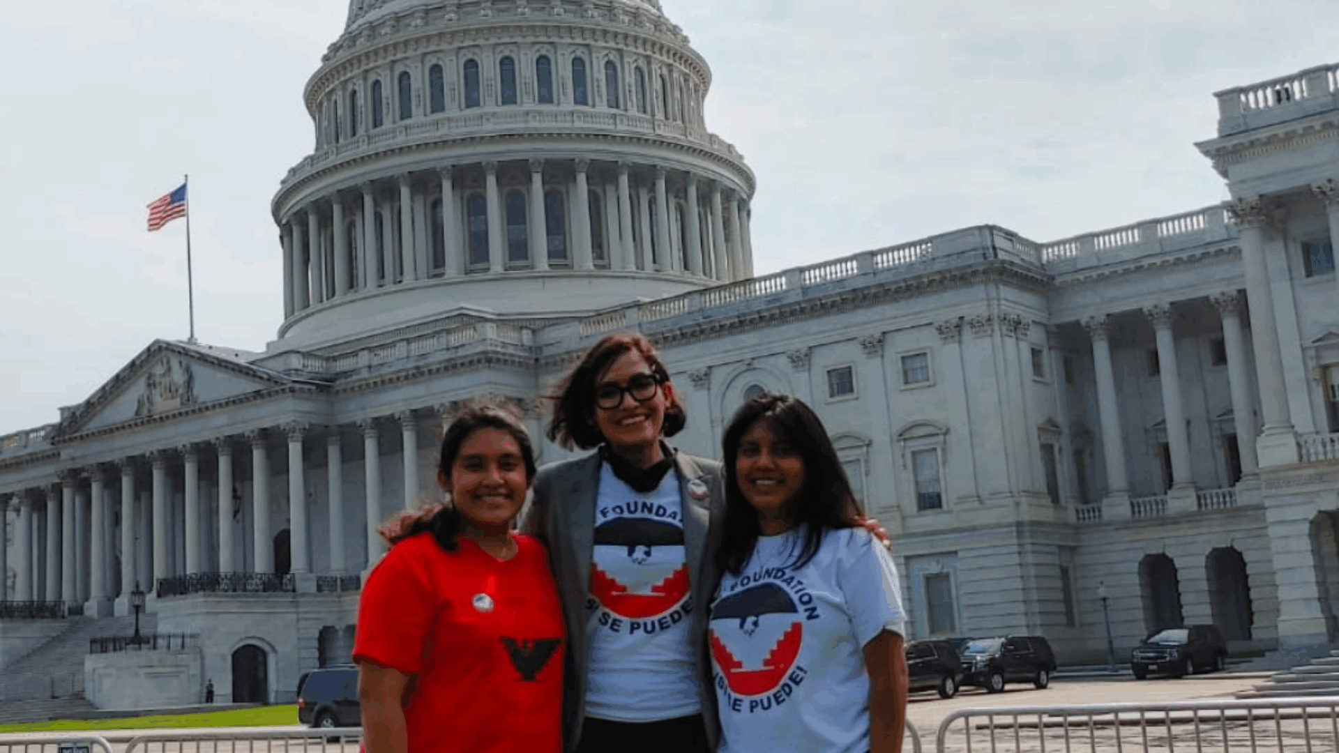 Three women are gathered in front of the U.S. Capitol building, capturing a moment of camaraderie and pride.