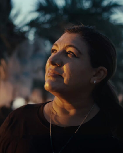 Un primer plano de una mujer que mira ligeramente hacia arriba con una expresión serena.